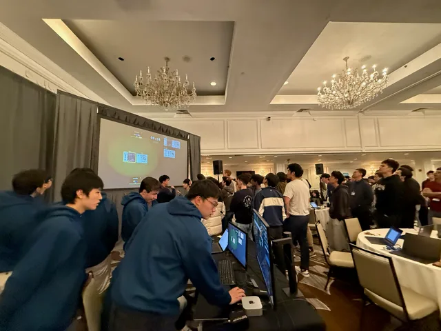 Competitors in the ballroom facing the presentation screen